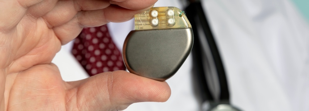 Male Hand hold Pacemaker in front of camera with blue background