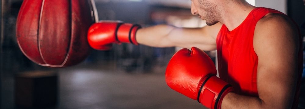 Man exercises in a boxing gym considering the benefits of cardio versus weight training for heart health according to Nevada Cardiology