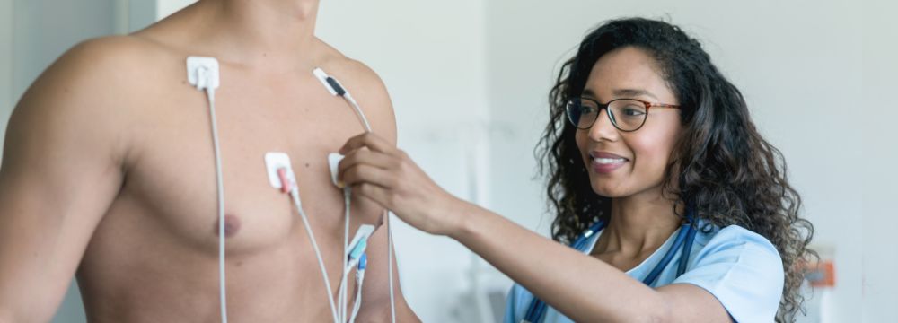 Technician places sensors before beginning a cardiac stress test to detect potential heart troubles