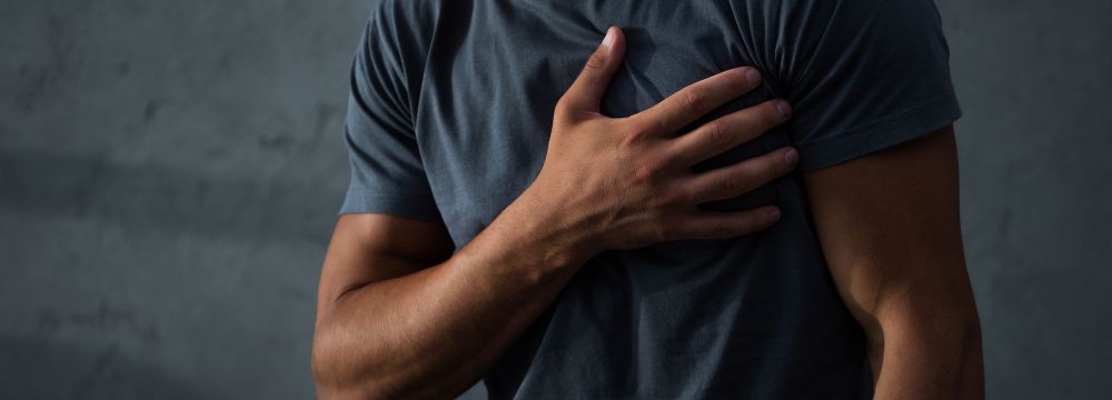 Man clenching chest with right hand