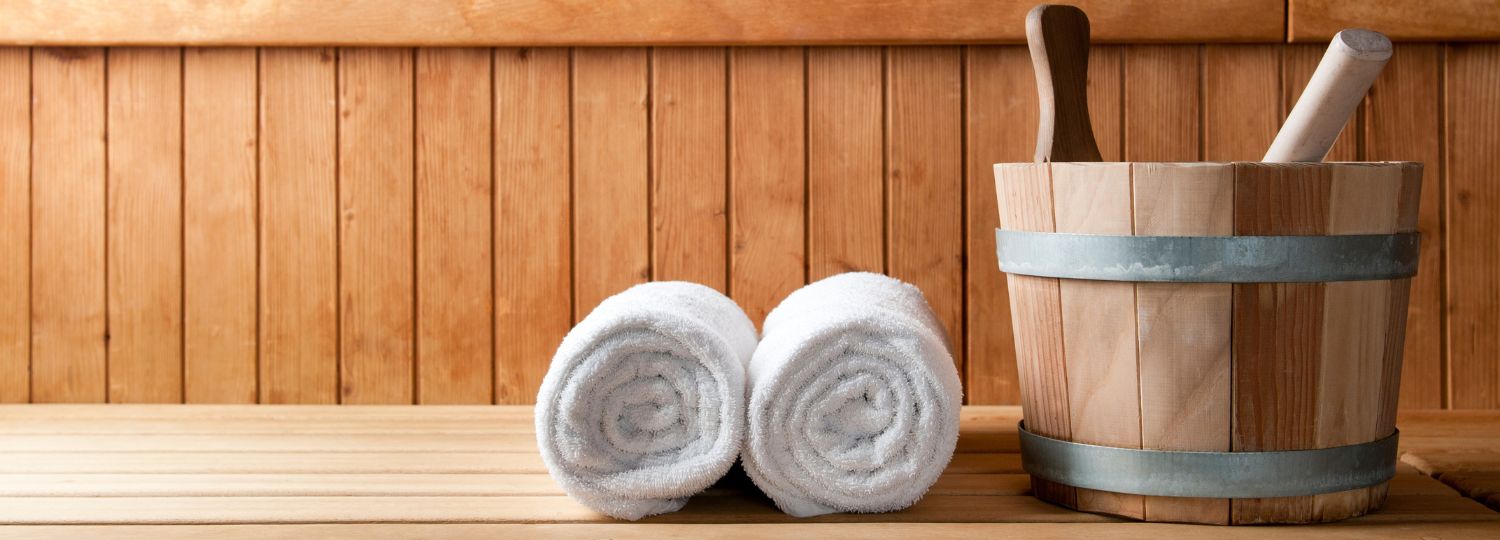 two towels and bucket sitting on sauna bench